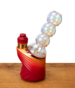 Seitenansicht des Big Fun Peak Pro Glass. Der schillernde Kugel-Perkolator-Aufsatz ist fest mit der roten Vaporizer-Basis verbunden.