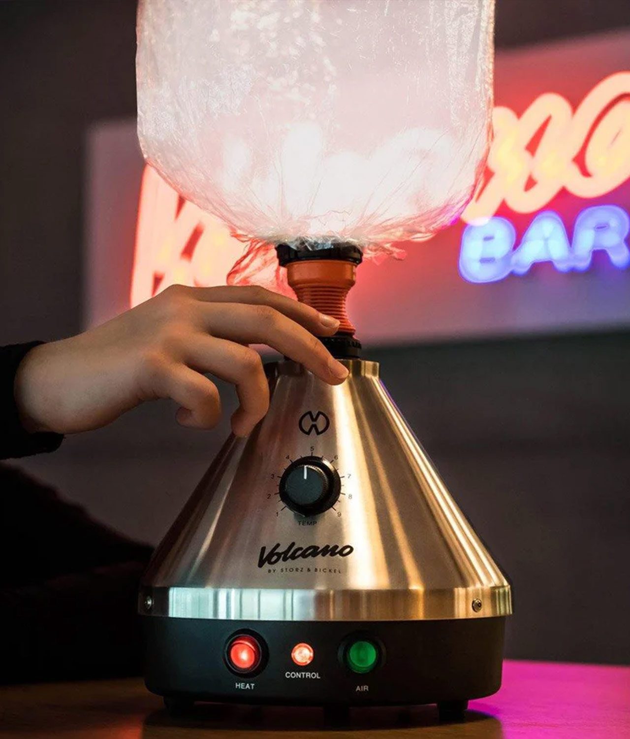 storz-und-bickel-volcano-classic-vaporizer-1-jpg Lifestyle Aufnahme des Volcano Classic Vaporizer mit Dampf in Ballon und LED Schild im Hintergrund