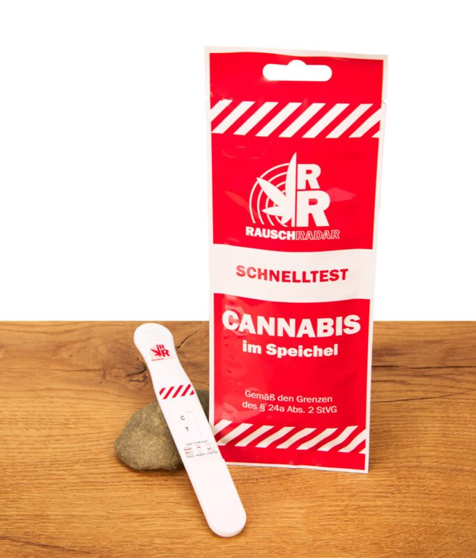 Rauschradar Cannabis Speichel-Schnelltest mit roter Verpackung und weißer Testkassette auf einem Stein und Holztisch.