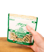 Purize Regular Size Organic 50er Pack Aktivkohlefilter (9 mm) in der Hand gehalten über einer Holzoberfläche.