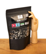 Kailar Big Size 9mm 420er Pack Aktivkohlefilter neben einer dekorativen Gliederhand aus Holz auf einem Tisch.