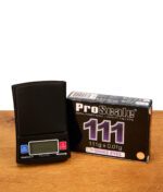 Schwarze ProScale 111 Digital Pocket Scale neben ihrer Produktverpackung auf einem Holztisch platziert.