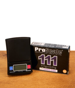 Schwarze ProScale 111 Digital Pocket Scale neben ihrer Produktverpackung auf einem Holztisch platziert.