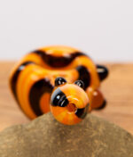 Fokussierte Nahaufnahme vom runden Mundstück der orange-schwarzen Calvo Unique Spoon Pipe Glaspfeife.