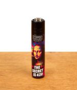 Nachfüllbares Clipper FFX The Royal Puff Reibradfeuerzeug mit Mona-Lisa-Motiv und Schriftzug „The secret is 420“ auf einer Holzplatte.