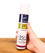 Hand hält die Clipper Feuerzeuggas 300ml Pure Isobutane Dose. Frontansicht mit Universal-Schriftzug über einem Holztisch.