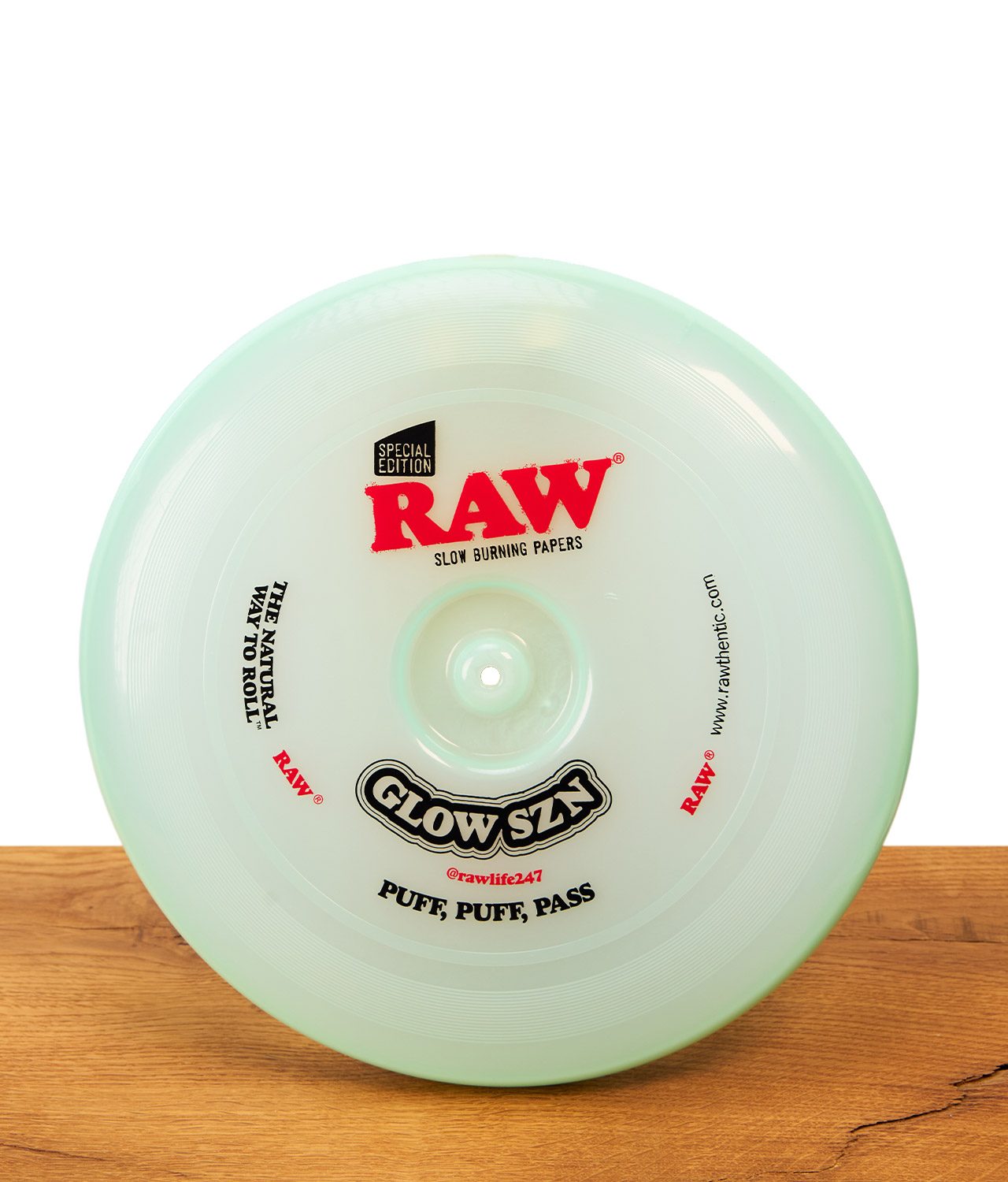 raw-frisbee-cyan-jpg RAW Frisbee Cyan Glow SZN Special Edition: Runde, mintgrüne Kunststoff-Frisbee und Rolling Tray auf einer Holzoberfläche.