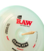 RAW Frisbee Cyan Glow SZN Special Edition aus Kunststoff mit eingestecktem Joint in der Mitte als Rolling Tray Zubehör.