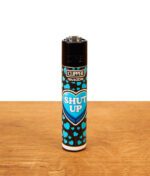 Das hellblaue Motiv-Feuerzeug aus der Clipper FFX Kiss me #3 Serie mit kleinen blauen Herzen und der Aufschrift „SHUT UP“ im zentralen Herz-Icon.