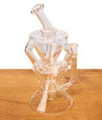 MJ Arsenal Triad Mini Rig aus klarem Borosilikatglas mit Recycler-System auf einem Holztisch.