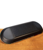 Schwarze Rückseite des RAW x Chris Psiacik Skate Deck Rolling Trays auf Holz mit strukturiertem, rutschfestem Gummipad.