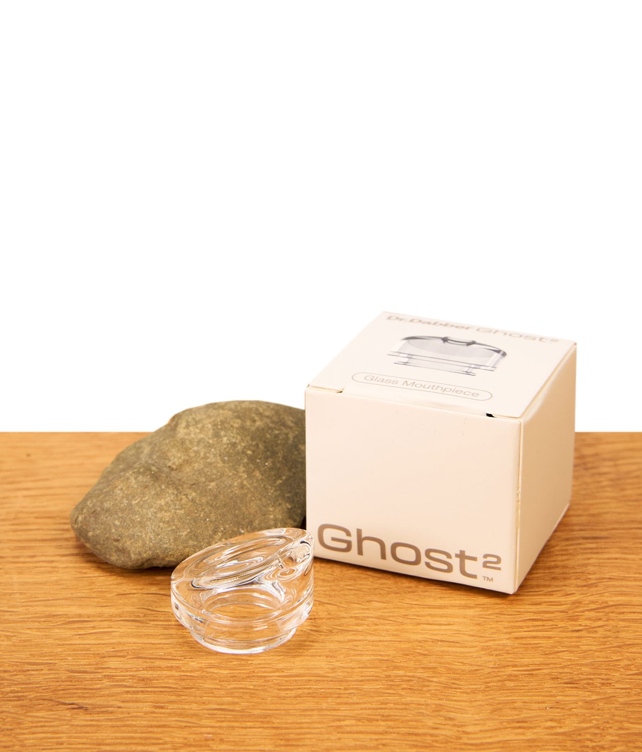 ghost-2-mundstueck-jpg Dr. Dabber Ghost 2 Glas Mundstück aus klarem Glas neben der weißen Originalverpackung auf Holz.