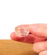 Transparentes Dr. Dabber Ghost 2 Glas Mundstück zwischen Fingern gehalten, zeigt die kompakte Größe.