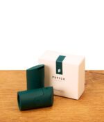 Zwei grüne Puffco Pivot Mundstücke aus Silikon neben der weißen Originalverpackung auf Holz, Fokus auf ergonomischem Design.