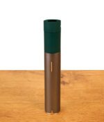 Grünes Puffco Pivot Mundstück aus Silikon, bündig montiert auf dem schlanken Metallgehäuse des Vaporizers auf einer Holzfläche.