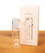 Dr. Dabber Switch 2 Ersatzglas aus Borosilikatglas neben seiner weißen Verpackung auf einer Holzoberfläche.