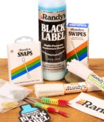 Ausgepacktes Randy's Reinigungsset mit Black Label Cleaner, Pfeifenreinigern, Bürsten, Metallsieben und Snaps auf Holz.