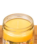 Nahaufnahme der glatten gelben Wachsoberfläche und des Dochts der geöffneten Smoke Odor Bubbly Mimosa Anti-Rauch-Kerze.