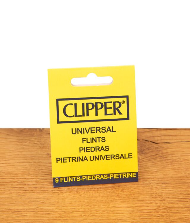Gelbe Verpackung der Clipper Universal Feuersteine im 9er Pack stehend auf einer hellen Holzoberfläche.