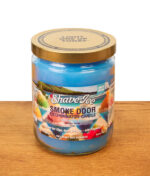 Smoke Odor Exterminator Candle Shave Ice im Glas mit blauem Wachs und geschlossenem Metalldeckel auf Holz.