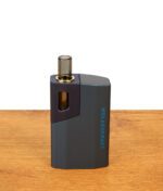 Wolkenkraft Äris Ultra Nightblue Vaporizer auf Holztisch. Blaues Aluminiumgehäuse, magnetische Kappe und Borosilikatglas-Mundstück.
