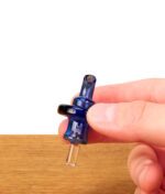 Hand hält blaue Human Grade Directional Carb Cap aus Borosilikatglas vor weißem Hintergrund.