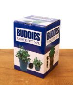 Originalverpackung des Buddies Flower Pot Safe auf einem Holztisch. Blau-weißer Karton der Versteckdose mit Produktabbildungen.