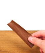 Geöffneter brauner Futurola Blunt Wrap wird über einem Holztisch in der Hand gehalten, zeigt die glatte, tabakfreie Struktur.