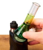 Hand setzt den grünen BigFun Tricolor Peak Top Glasaufsatz aus Borosilikatglas auf ein Puffco Peak Rig.