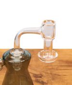 Human Grade Terp Slurper 90° Quarzbanger auf einer dunklen Glass-Dab-Rig montiert auf Holz.