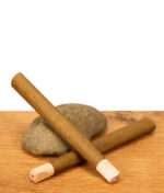 Zwei vorgedrehte Cyclones Hemp Cones Wonder Cones aus Hanf mit Holzmundstück auf Holztisch.