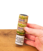 Hand hält eine luftdichte Transporttube der Cyclones Hemp Cones Wonder über einem Holztisch.